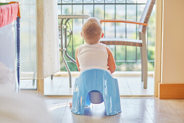 Child is sitting on a potty with a beautiful mountain view
