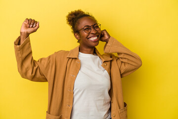 Young african american woman isolated on yellow background dancing and having fun.