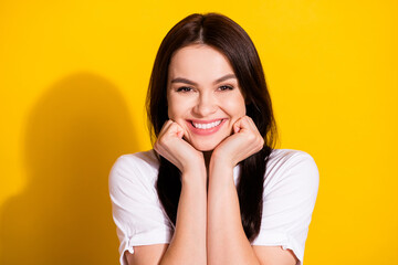 Fototapeta na wymiar Photo of adorable charming young woman wear white t-shirt smiling arms cheeks isolated yellow color background