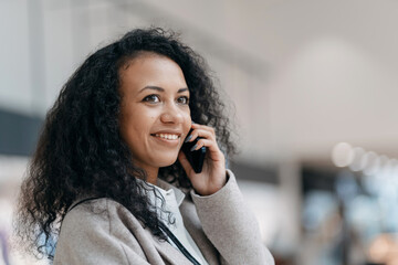 young woman talking on a smartphone in the cafeteria of a shopping center .