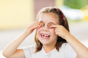 Happy little girl being silly with chocolate freckles on her face