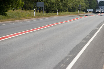Fototapeta na wymiar Asphalt road with double lane road stripes white and red