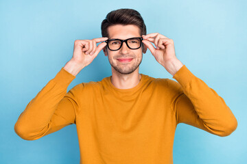 Photo of young handsome man happy positive smile put eyeglasses vision isolated over blue color...