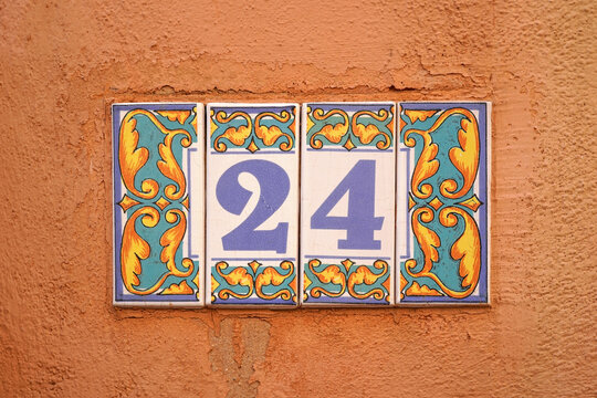 decorated ceramic tiles 24 house number on orange rough wall