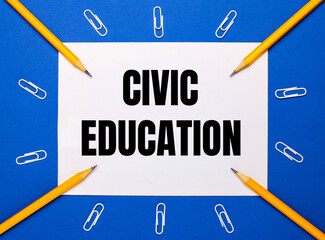 On a blue background, white paper clips, yellow pencils and a white sheet of paper with the text...