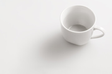 Empty coffee cup on white surface with copy space
