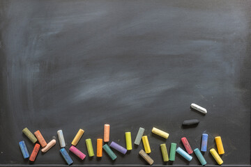 Blackboard with scattered chalks along the bottom