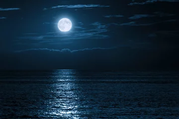 Keuken foto achterwand Volle maan This large full blue moon rises brightly over the cloud bank in this calm ocean