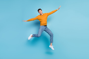 Fototapeta na wymiar Full length body size view of attractive cheerful lucky guy jumping having fun isolated over bright blue color background