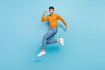 Fototapeta na wymiar Full body profile side photo of young man happy positive smile go walk run jump up hurry isolated over blue color background