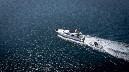 Aerial view of luxury speedboat yacht cruising in deep ocean water.