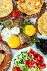 Homemade Romanian Food with grilled fish, polenta, pies, vegetables with red wine. Platter on camping.