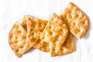 Italian crunchy focaccia on a light background, top view. Traditional italian bread