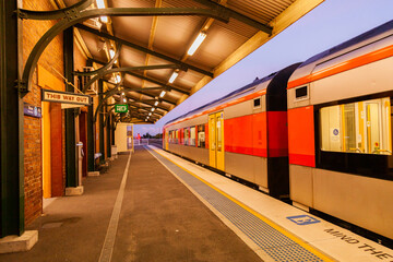 Passenger train pulling away from deserted country railway station