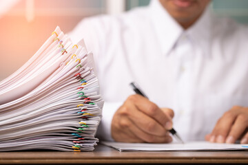 Business man or office workers with white shirt holding documents for writing on office desk, Stack of business overload paper.