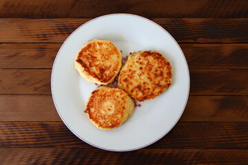 Homemade cheesecakes on a plate on the dark wooden background