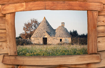 An abandoned Italian trullo (trulli), a country house of peasants in southern Italy, seen through a wooden window frame. Medium shot.
 - obrazy, fototapety, plakaty