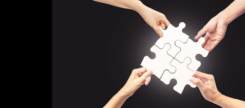 Hands holding White jigsaw puzzles on dark background, The concept of a business idea, Teamwork, Strategy, Coperation