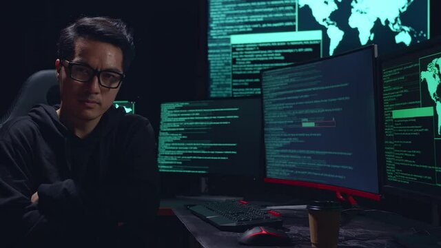 Asian Man Hacker Pose With Code On Multiple Computer Screens
