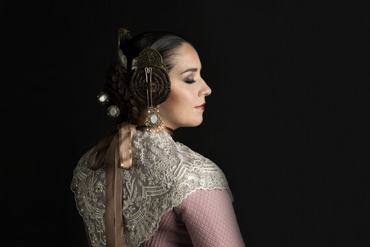 Caucasian white woman dressed as fallera on black background