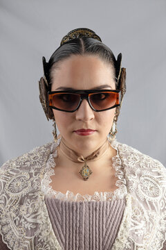 Portrait of young fallera modeling sunglasses while looking at you