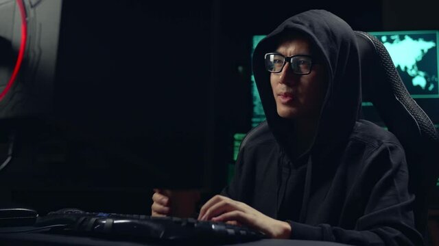Asian Male Hacker Using Computer Hacking And Drinking Coffee
