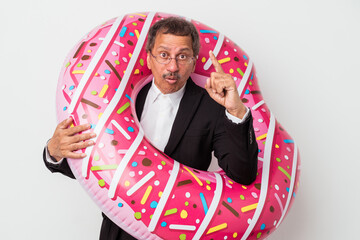 Senior indian business man holding inflatable donut isolated on white background having an idea,...