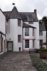 Fototapeta na wymiar 18th Century Traditional White Painted Scottish House with Stone Patio & Bench