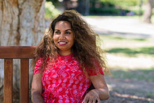 aboriginal woman sitting on a bench in a park