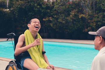 Confident asian disabled child on wheelchair and adult with fun on swimming pool background,...