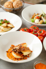 pancakes with sea buckthorn jam and lots of food in the background on concrete table closeup