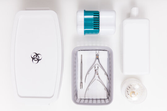 Top view shot of sterilizing box and liwuid disinfectant bottle near manicure instruments