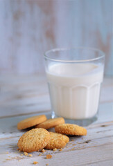 Brown cookies with a glass milk  on a vintage wooden background