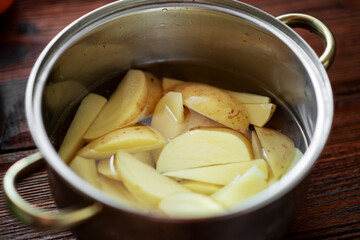 Raw chopped potatoes in a pot of water. Preparation for cooking.
