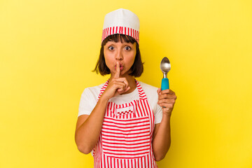 Young mixed race ice cream maker woman holding an ice cream scoop isolated on yellow background keeping a secret or asking for silence.