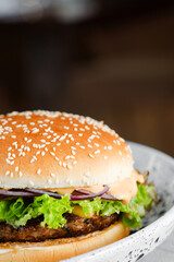 Close-up of home made tasty burger in ceramic plate
