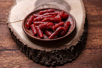 Dried smoked sausages on a wooden background. Beer snack.