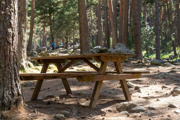 Fototapeta na wymiar mesa y bancos de madera en un merendero en la montaña al aire libre