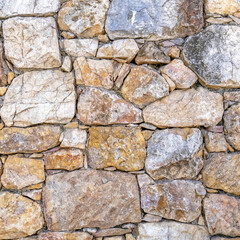 rough various colored stone wall closeup, seamless natural background