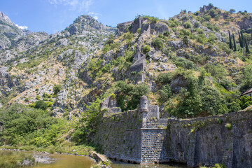Fototapeta na wymiar Medieval security wall surrounding the old town. Military tower. Ruins of a fortress at the top of the mountain. Fortifications of Kotor, Montenegro.
