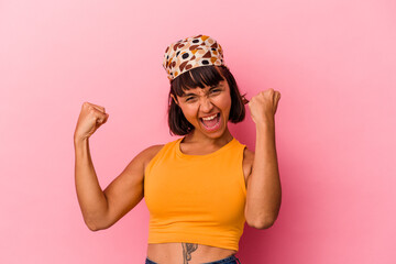 Young mixed race woman isolated on pink background cheering carefree and excited. Victory concept.