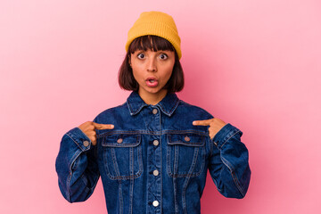 Young mixed race woman isolated on pink background points down with fingers, positive feeling.