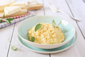 Fotobehang Creamy Brie cheese Risotto on sage broth © photosimysia