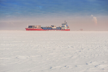 Winter shipping. Big cargo ship in frozen sea fairway