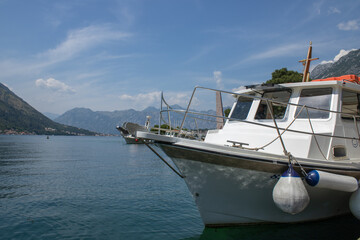 Fototapeta premium White boat in the mediterranean sea on the foreground. Bow of the ship close-up. Mountains and blue sky on the background.