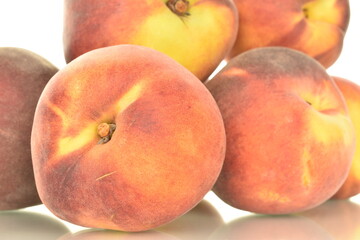 Several ripe organic peaches, close-up, isolated on white.