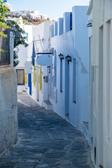 Whitewashed buildings cobblestone alley background at Sifnos island, Greece.