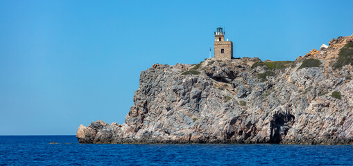 Lighthhouse building on a rocky cliff. Ios island Greece. Cyclades © Rawf8