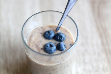 Banana and blueberry vegan nice cream, served on wooden table. Selective focus.