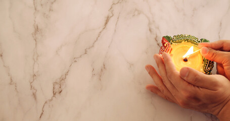 Top view of hands burning a candle with a match on white background